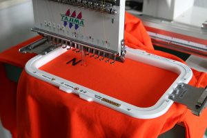 Embroidery machine branding a logo