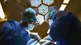 Surgeons placing artificial wearable organ