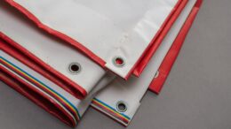 A red and white billboard. PVC fabric folded. Banner with eyelets. Selective focus.