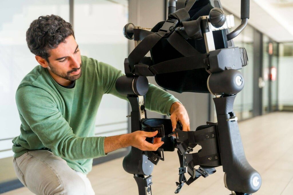 Mechanical exoskeleton engineer checking the robot.