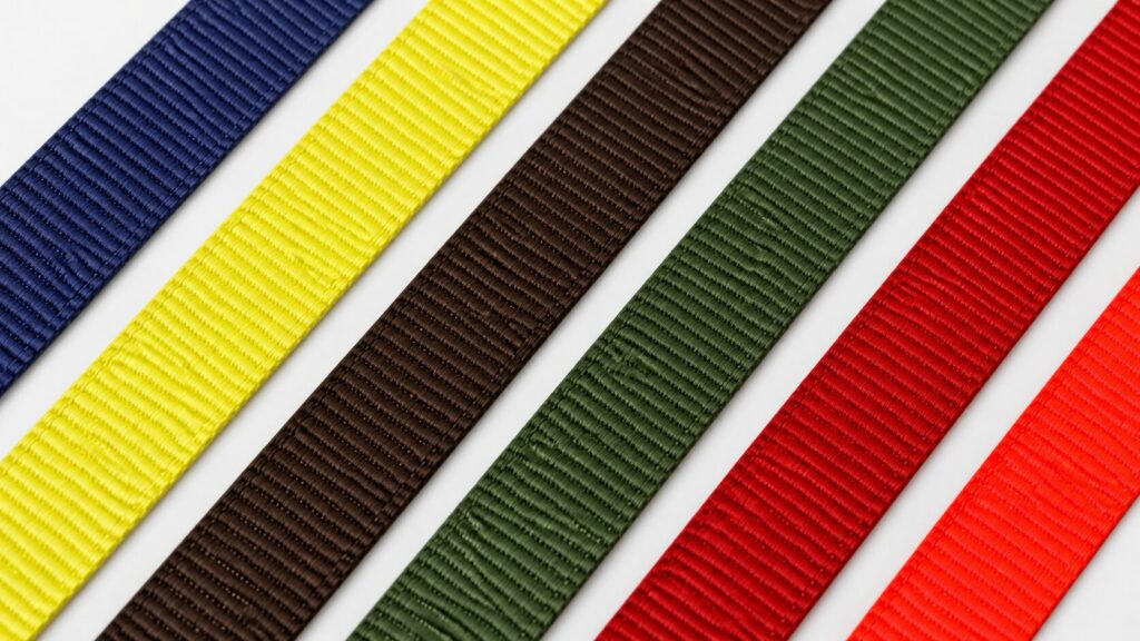 A range of flat webbing laid flat, in various colors